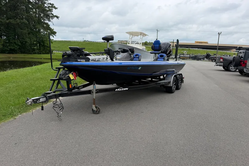 Slide: The Image of 2022 Falcon F20 boat on trailer, parked on a paved road near grassy area. - 2