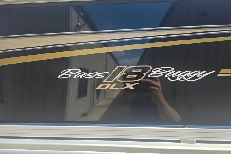 Slide: The Image of 2021 Sun Tracker Bass Buggy 18 DLX logo on a sleek black surface. - 17