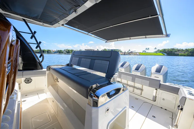 Slide: The Image of 2024 Boston Whaler 42 OUTRAGE boat interior with seating and canopy on a sunny day. - 58