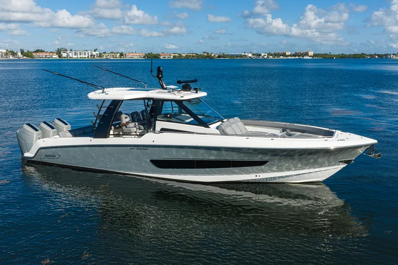 Slide: The Image of 2024 Boston Whaler 42 OUTRAGE boat on calm water, showcasing sleek design and powerful engines. - 70