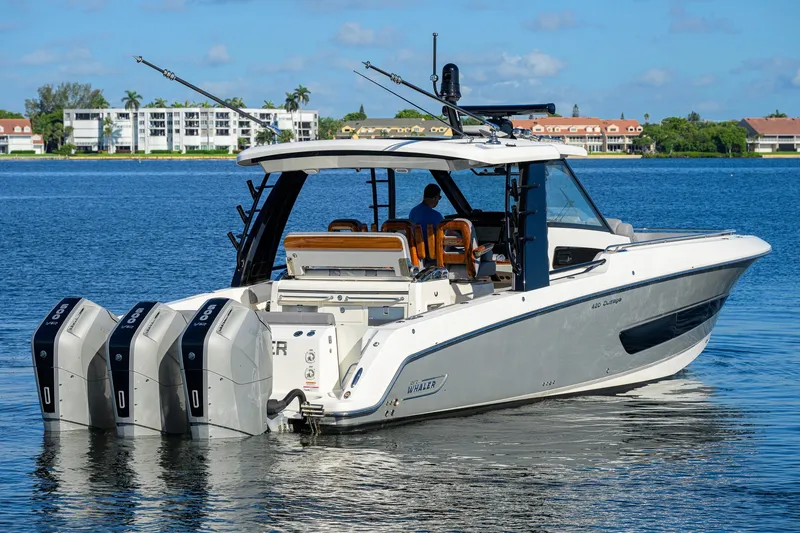 Slide: The Image of 2024 Boston Whaler 42 OUTRAGE boat with triple engines on a serene lake. - 68