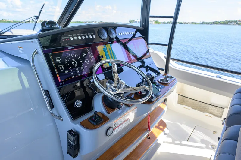 Slide: The Image of 2024 Boston Whaler 42 OUTRAGE helm with advanced navigation displays and steering wheel. - 49