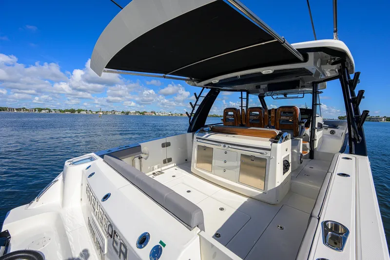 Slide: The Image of 2024 Boston Whaler 42 OUTRAGE boat with spacious deck and seating, docked on a sunny day. - 42