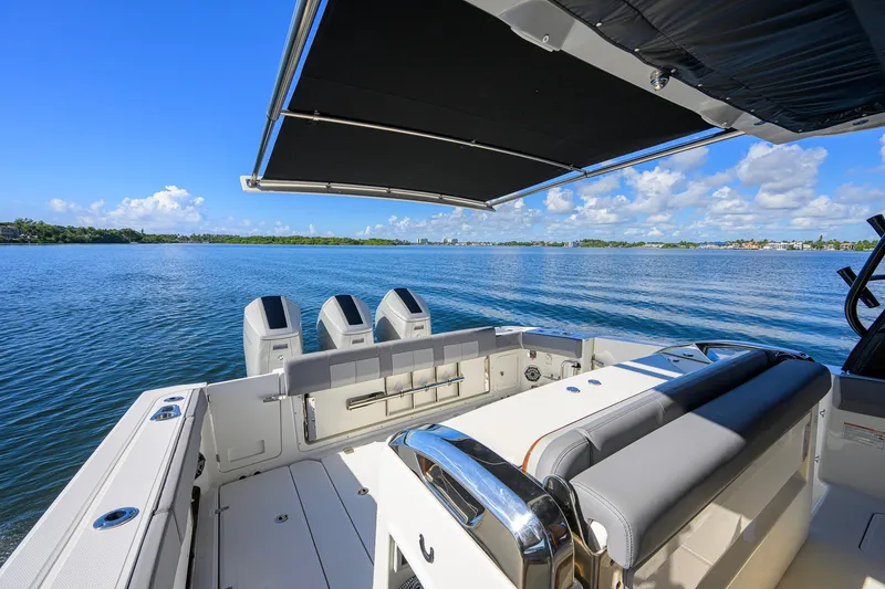 Slide: The Image of 2024 Boston Whaler 42 OUTRAGE boat with canopy, overlooking serene blue waters. - 41