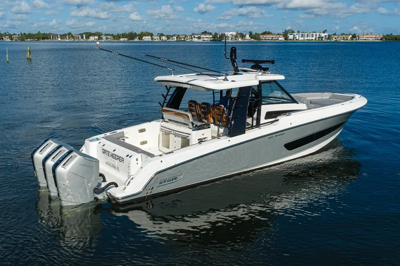 Slide: The Image of 2024 Boston Whaler 42 OUTRAGE boat on calm water, featuring triple outboard engines. - 55