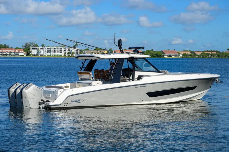 Slide: The Image of 2024 Boston Whaler 42 OUTRAGE boat on calm water, showcasing sleek design and powerful engines. - 69