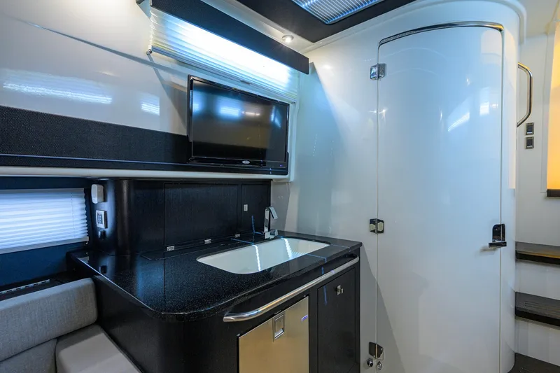 Slide: The Image of Luxurious interior of 2024 Boston Whaler 42 OUTRAGE with modern kitchenette and TV. - 19