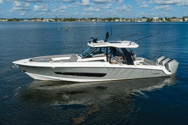 Slide: The Image of 2024 Boston Whaler 42 OUTRAGE boat on calm water, showcasing sleek design and powerful engines. - 74