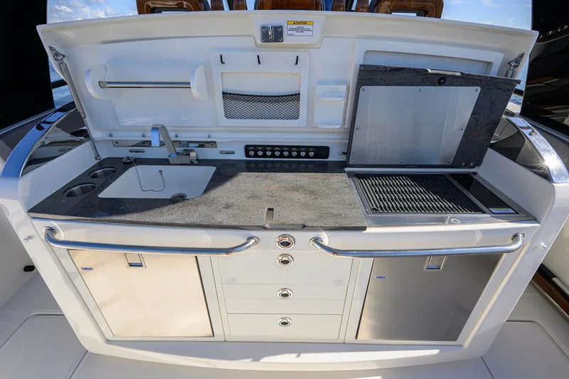 Slide: The Image of 2024 Boston Whaler 42 OUTRAGE boat kitchen with sink, grill, and storage. - 38