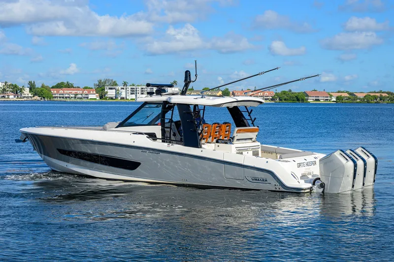 Slide: The Image of 2024 Boston Whaler 42 OUTRAGE boat on calm water, featuring sleek design and powerful engines. - 65