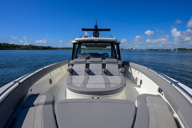 Slide: The Image of 2024 Boston Whaler 42 OUTRAGE boat on calm water under clear blue sky. - 8