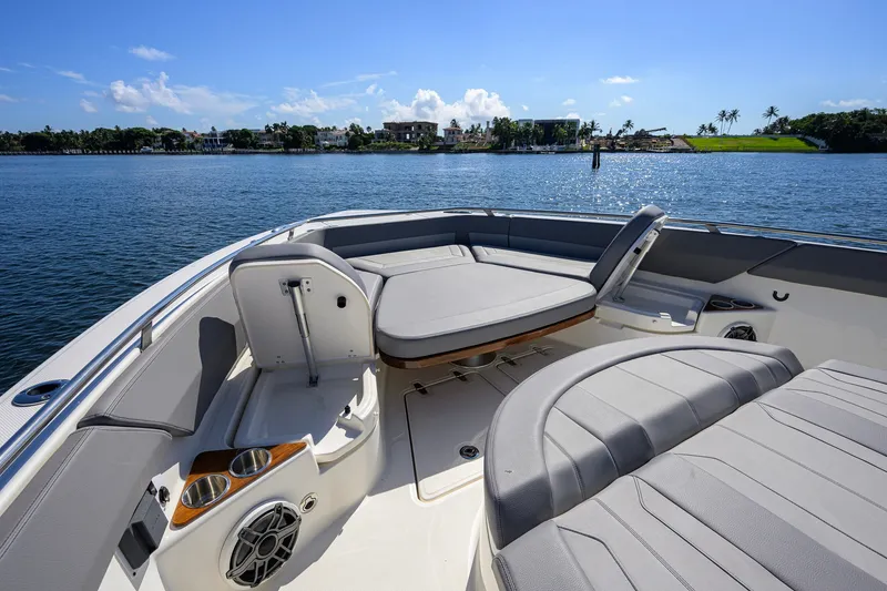 Slide: The Image of Luxurious seating on 2024 Boston Whaler 42 OUTRAGE boat, with scenic waterfront view. - 12