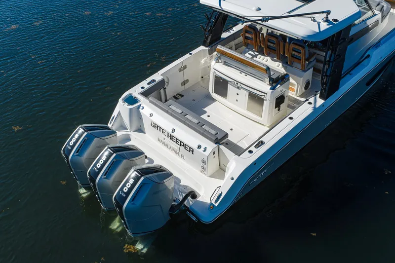 Slide: The Image of 2024 Boston Whaler 42 OUTRAGE boat with triple Mercury engines on calm water. - 24