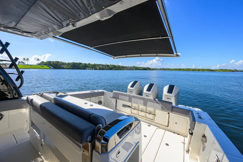 Slide: The Image of 2024 Boston Whaler 42 OUTRAGE boat with triple engines, spacious deck, and scenic water view. - 39