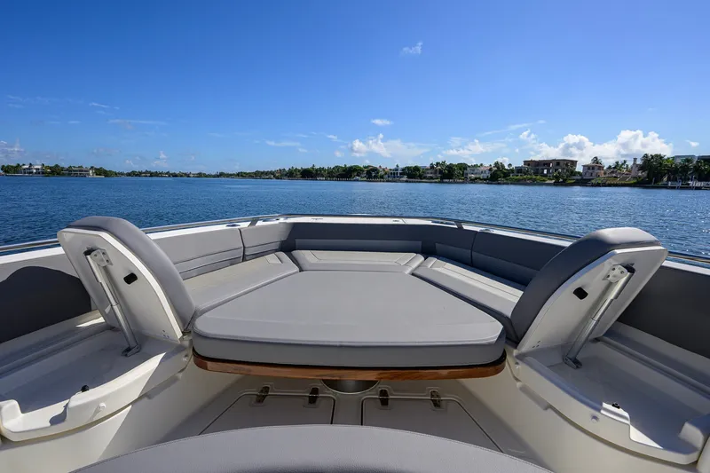 Slide: The Image of 2024 Boston Whaler 42 OUTRAGE boat interior with cushioned seating on a sunny day. - 11