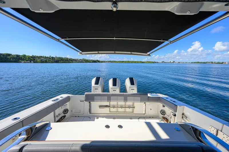 Slide: The Image of 2024 Boston Whaler 42 OUTRAGE boat with triple engines on a serene lake. - 40