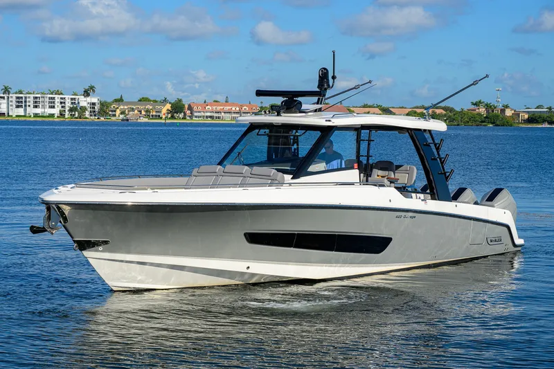 Slide: The Image of 2024 Boston Whaler 42 OUTRAGE boat cruising on a sunny day, with scenic waterfront backdrop. - 63