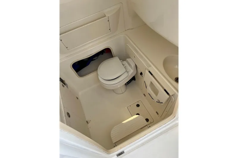 Slide: The Image of 2005 Boston Whaler Outrage 320 boat interior with compact marine toilet and storage. - 14