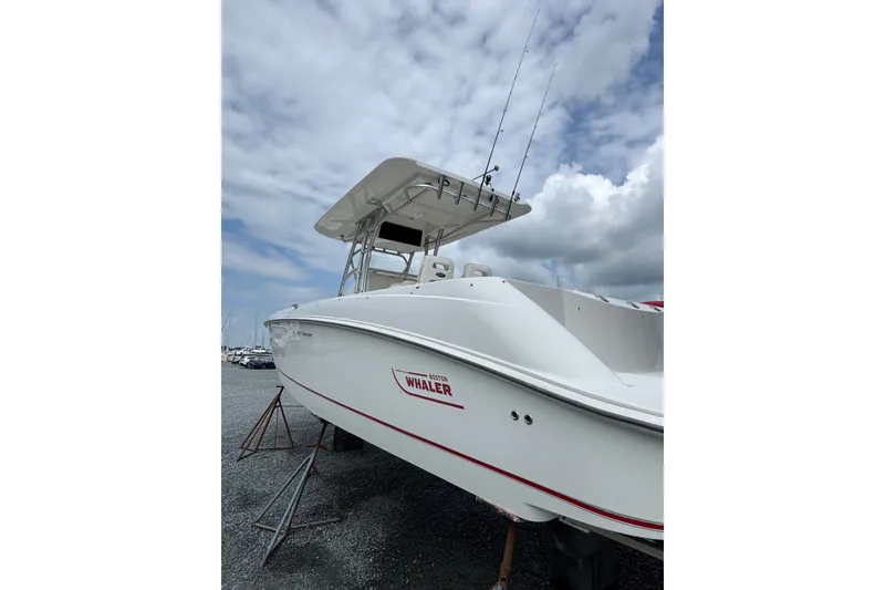 Slide: The Image of 2005 Boston Whaler Outrage 320 boat on stands under cloudy sky. - 2