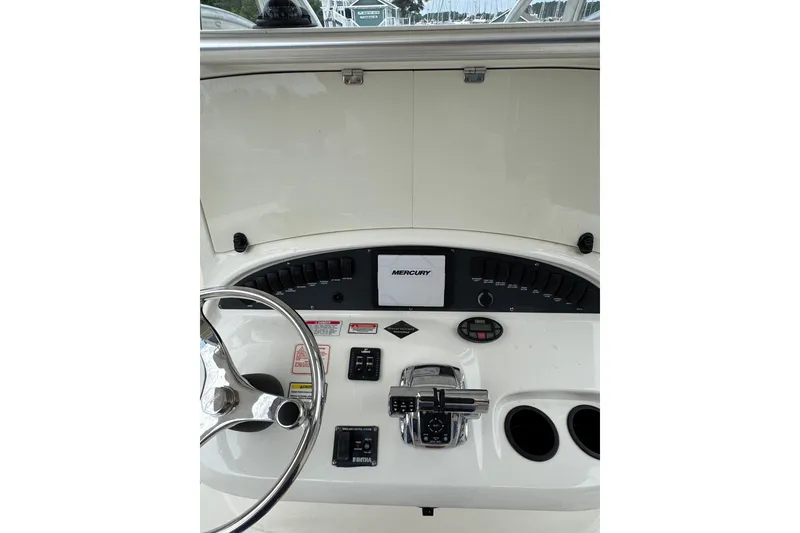 Slide: The Image of 2005 Boston Whaler Outrage 320 helm with steering wheel and Mercury controls. - 16