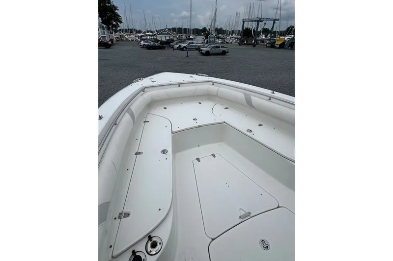 Slide: The Image of 2005 Boston Whaler Outrage 320 boat deck, parked in a marina with sailboats in background. - 6