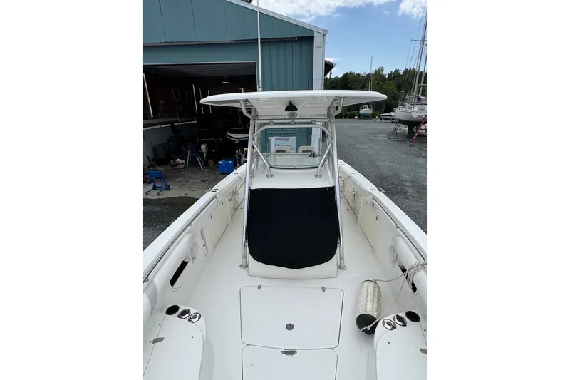 Slide: The Image of 2005 Boston Whaler Outrage 320 boat docked, showcasing spacious deck and sleek design. - 5