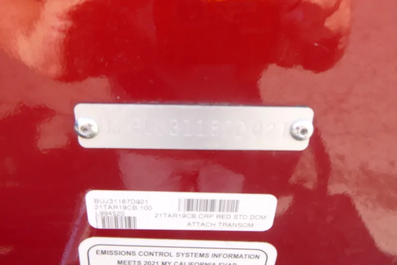 Slide: The Image of 2021 Tracker Targa V-19 Combo boat identification and emissions labels on red surface. - 19