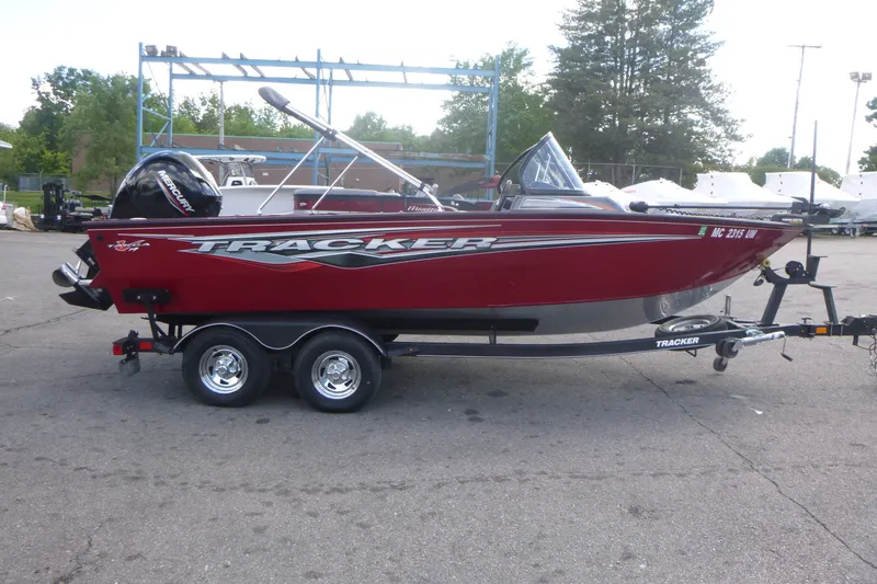 The Image of 2021 Tracker Targa V-19 Combo boat on trailer, red exterior, parked outdoors. - 1
