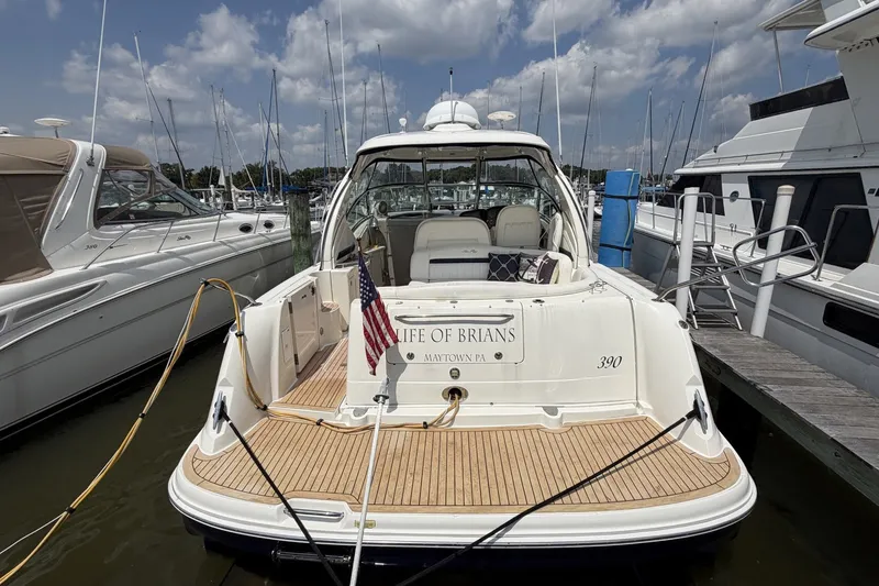 Slide: The Image of 2004 Sea Ray 390 Sundancer docked, featuring a spacious deck and American flag. - 3