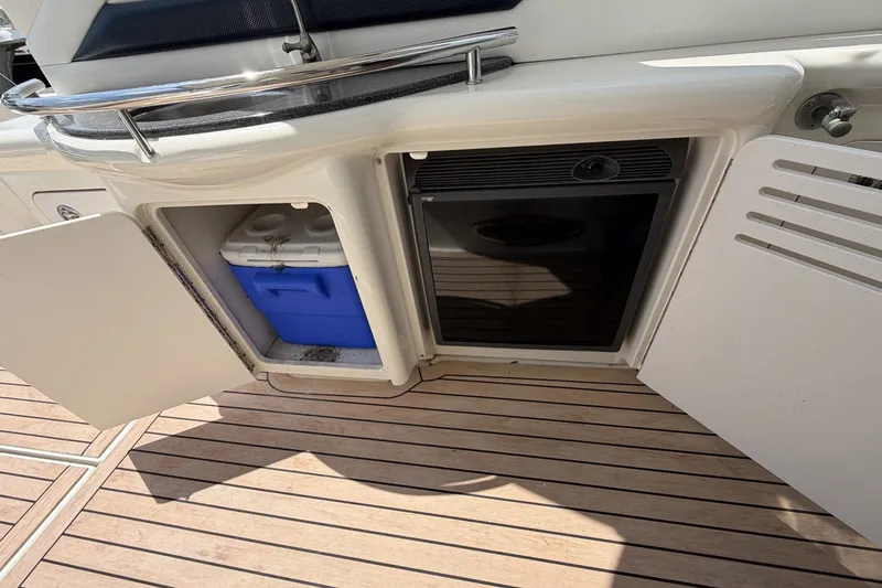 Slide: The Image of 2004 Sea Ray 390 Sundancer boat deck with storage compartments and cooler. - 8
