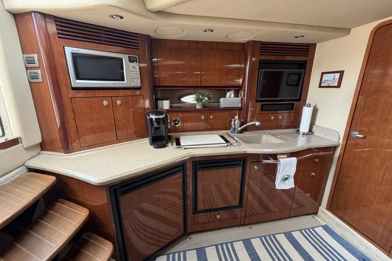 Slide: The Image of Luxurious 2004 Sea Ray 390 Sundancer yacht kitchen with wood cabinetry and modern appliances. - 29