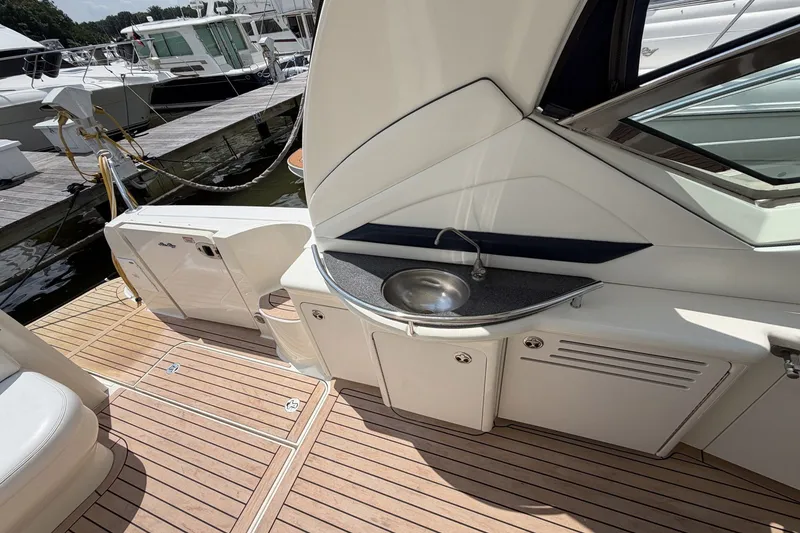 Slide: The Image of 2004 Sea Ray 390 Sundancer yacht deck with sink and storage cabinets. - 9