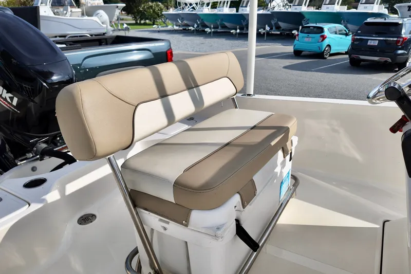 Slide: The Image of 2020 Pioneer 180 Sportfish boat interior with cushioned seating and cooler storage. - 6