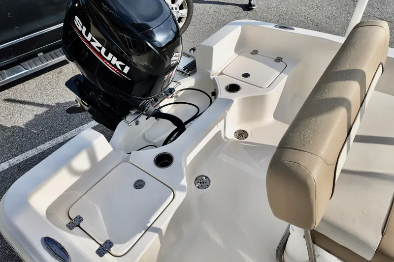 Slide: The Image of 2020 Pioneer 180 Sportfish boat with Suzuki outboard motor, beige seating, and storage compartments. - 7
