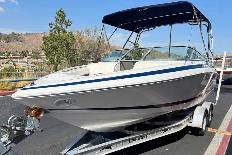 Slide: The Image of 2001 Cobalt 232 boat on trailer with canopy, parked outdoors under clear sky. - 3