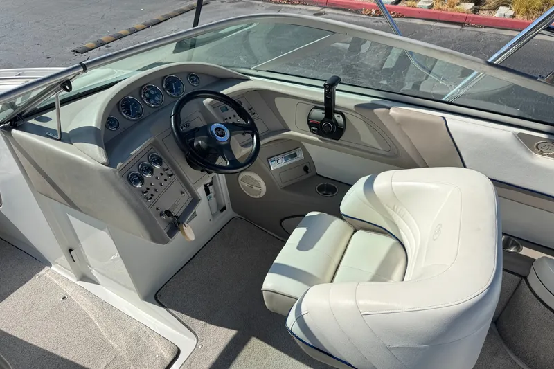 Slide: The Image of Interior of a 2001 Cobalt 232 boat featuring steering wheel and dashboard controls. - 28