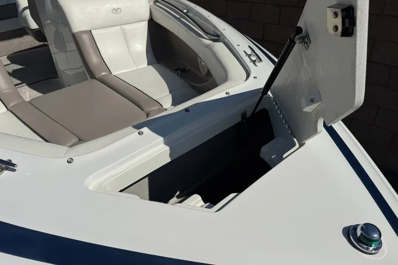 Slide: The Image of 2001 Cobalt 232 boat interior with open storage compartment and cushioned seating. - 11