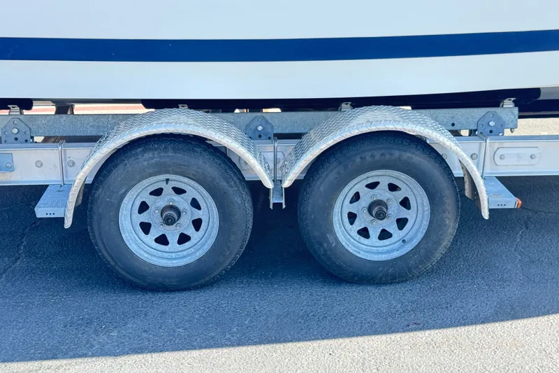 Slide: The Image of Trailer wheels of a 2001 Cobalt 232 boat on pavement. - 32