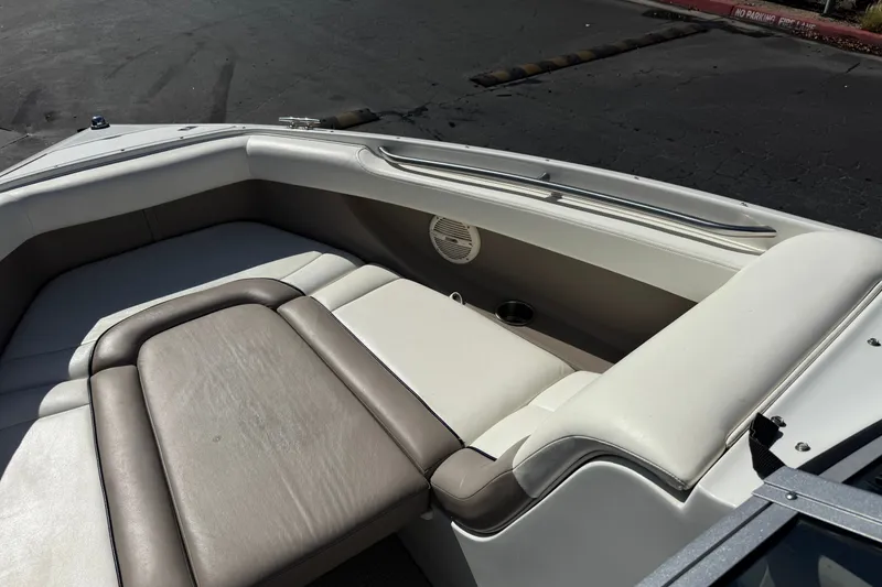 Slide: The Image of Interior of a 2001 Cobalt 232 boat featuring cushioned seating and cup holder. - 14