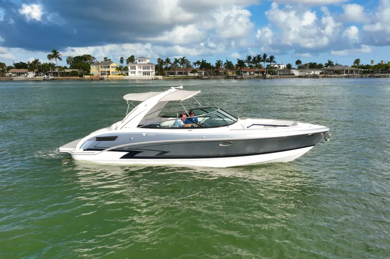 The Image of 2023 Formula 290 Bowrider cruising on a scenic waterway under a partly cloudy sky. - 1