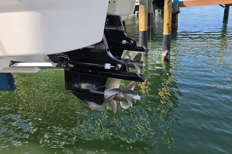 Slide: The Image of 2023 Formula 290 Bowrider boat propellers in water near dock. - 40