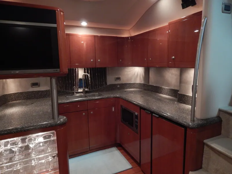 Slide: The Image of The 2006 Formula 48 Yacht's kitchen features sleek wood cabinets, granite countertops, and modern appliances. - 49