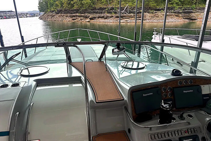 Slide: The Image of 2006 Formula 48 Yacht cockpit with navigation equipment, docked by a scenic shoreline. - 22
