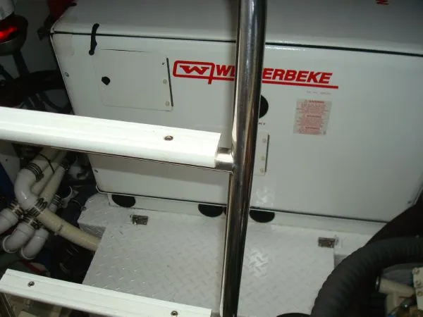 Slide: The Image of A Weterbeke generator in an engine room with white pipes and a metal ladder. - 34