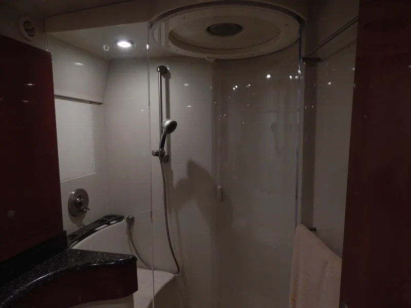 Slide: The Image of The yacht's shower is modern with glass doors and a handheld showerhead. - 47