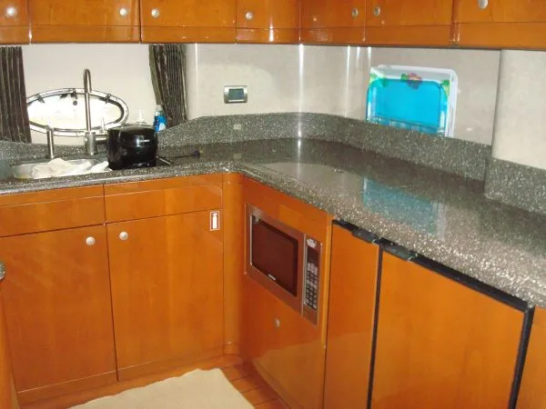 Slide: The Image of Galley of the 2006 Formula 48 Yacht with wood cabinets, granite countertops, and built-in microwave. - 24