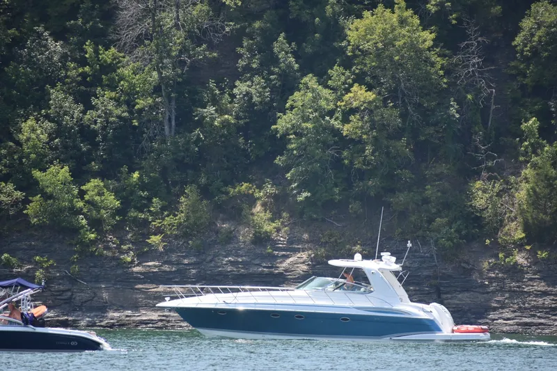 The Image of 2006 Formula 48 Yacht cruising on a scenic lake with lush forest backdrop. - 1