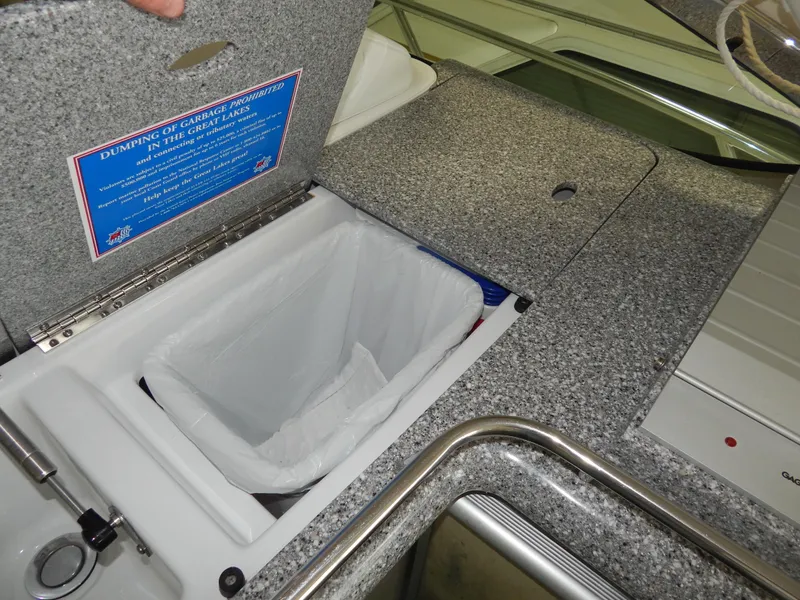 Slide: The Image of The image shows a kitchenette with an open trash bin lid and a sink. - 15
