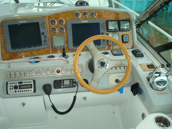 Slide: The Image of The cockpit of a 2006 Formula 48 Yacht with a wooden steering wheel and modern instruments. - 18