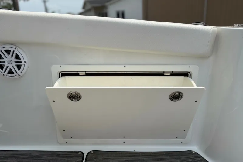 Slide: The Image of 2022 Wellcraft 262 Fisherman boat storage compartment with speaker, open hatch. - 14